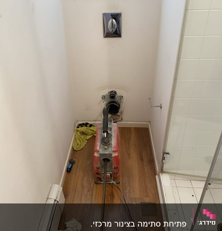 מכונת ניקוי צינורות אדומה בחדר אמבטיה